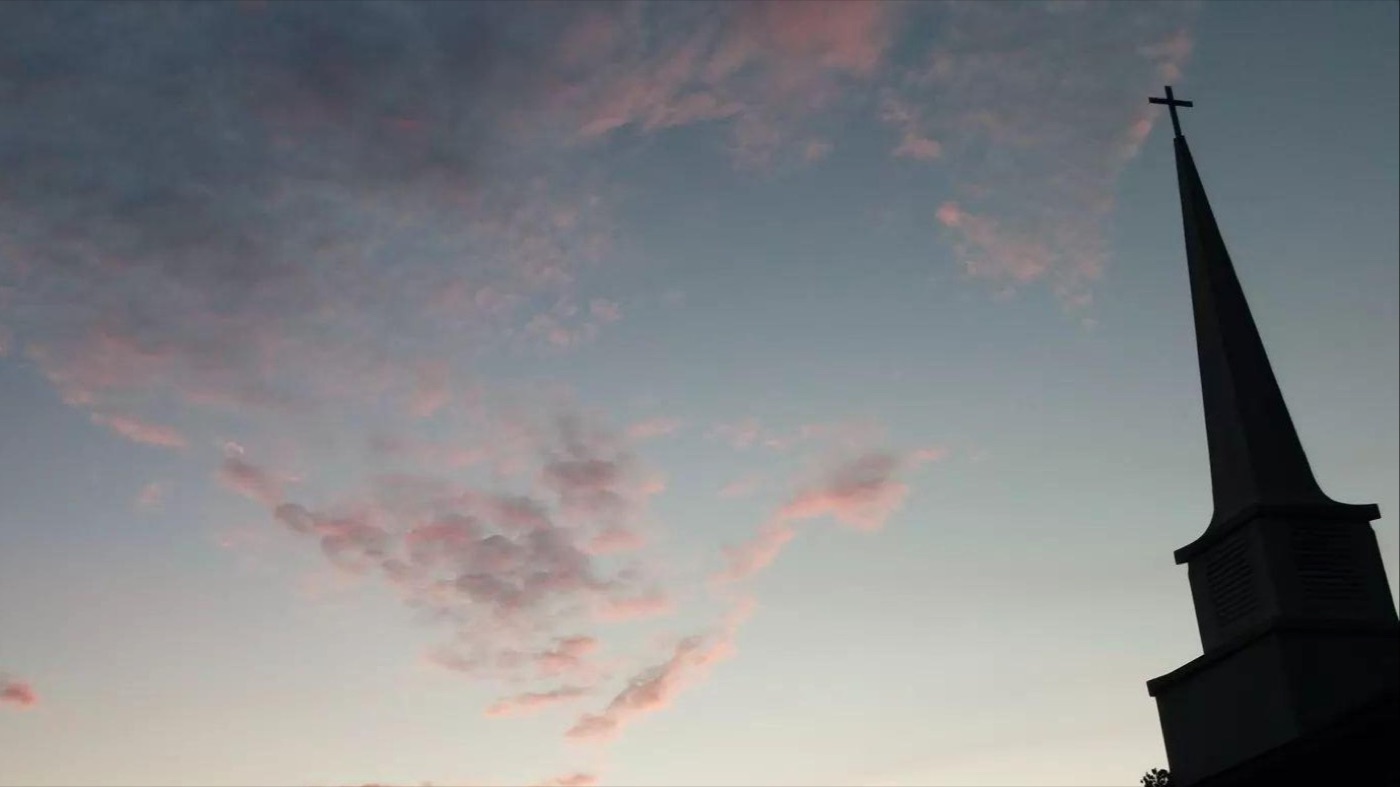 The steeple at Oak Grove Apostolic Church against a dusk sky